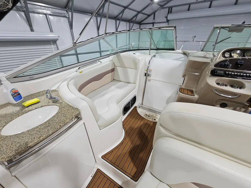 Slide: The Image of 2005 Chaparral Signature 330 boat interior with seating, sink, and control panel in a garage. - 7