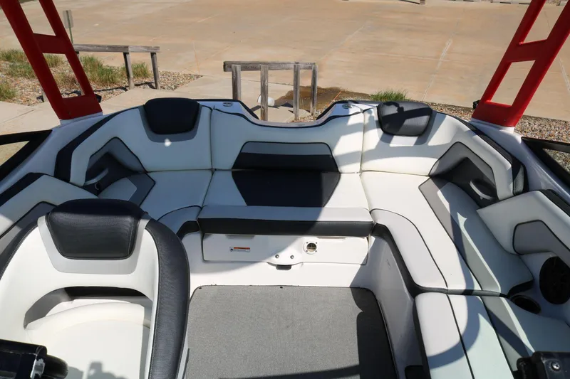 Slide: The Image of 2018 Yamaha Boats AR 195 interior with white and black seating, red accents, and spacious layout. - 13