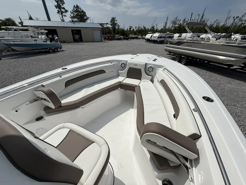 Slide: The Image of 2025 Tidewater 232 CC Adventure boat interior with seating and speakers, parked outdoors. - 12