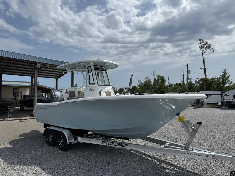 Slide: The Image of 2025 Tidewater 232 CC Adventure boat on trailer under cloudy sky. - 2