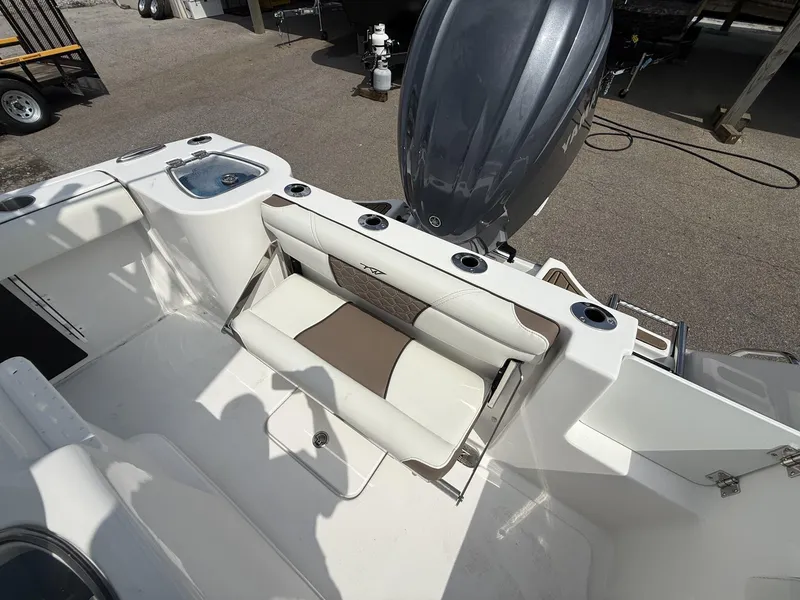 Slide: The Image of 2025 Tidewater 232 CC Adventure boat interior with seating and engine view. - 6