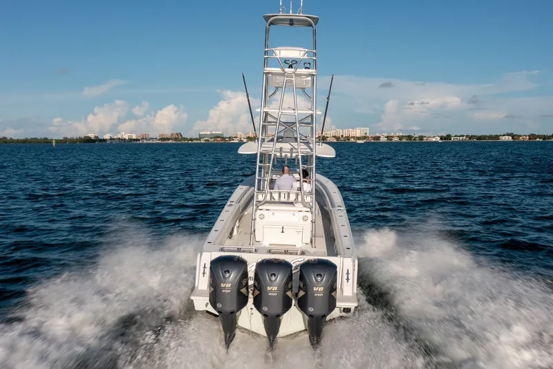 Slide: The Image of 2018 Contender 39 ST boat with triple Yamaha engines cruising on open water. - 10