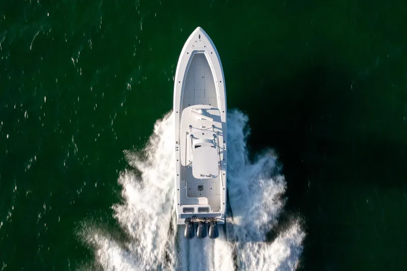 Slide: The Image of Aerial view of 2018 Contender 39 ST boat cruising on green water. - 13