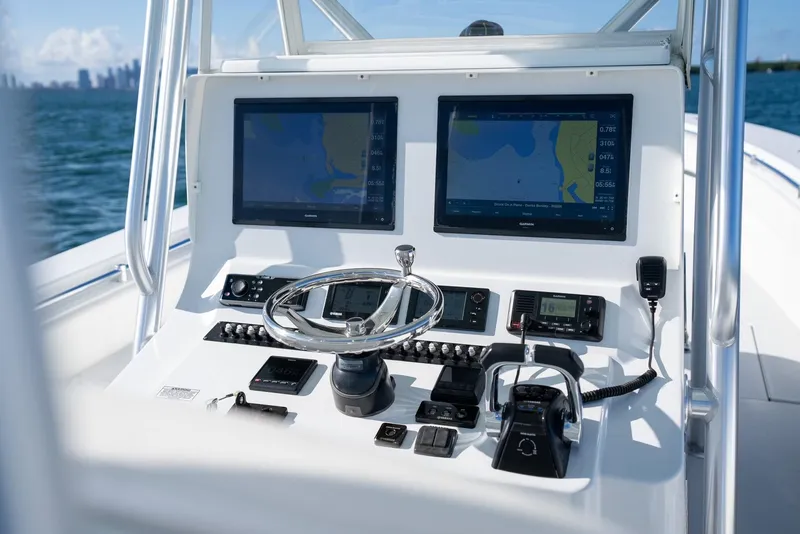 Slide: The Image of 2018 Contender 39 ST boat dashboard with dual navigation screens and controls. - 18
