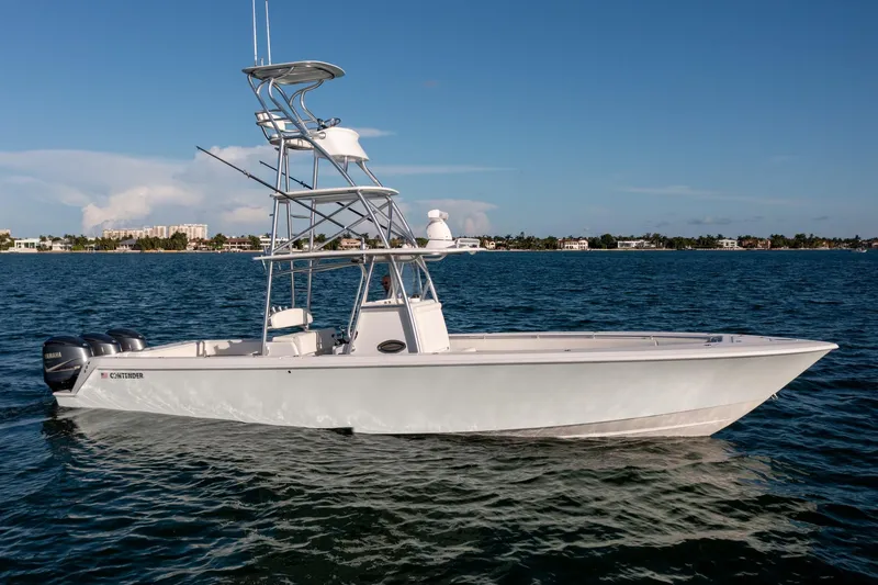 Slide: The Image of 2018 Contender 39 ST boat on calm water, featuring a sleek design and multiple engines. - 2