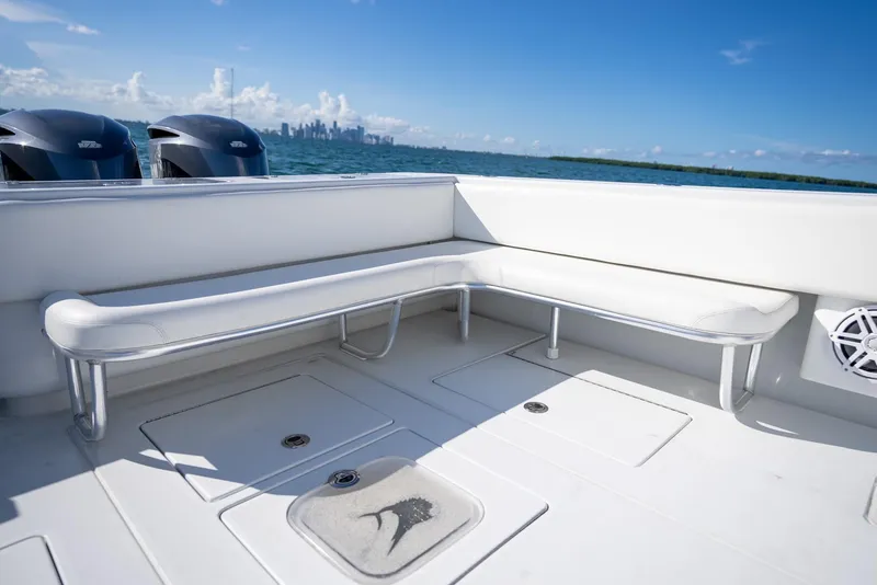 Slide: The Image of 2018 Contender 39 ST boat deck with seating, ocean view, and city skyline in background. - 20