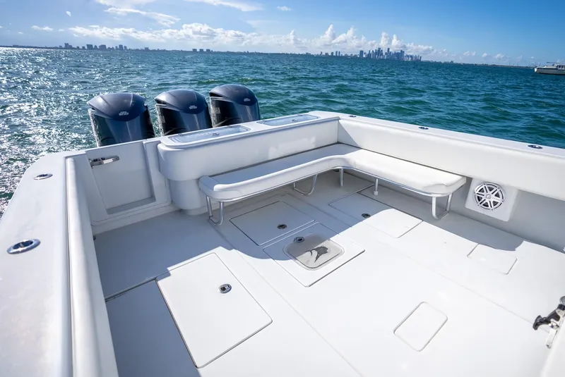 Slide: The Image of 2018 Contender 39 ST boat with spacious deck and triple outboard engines on open water. - 21