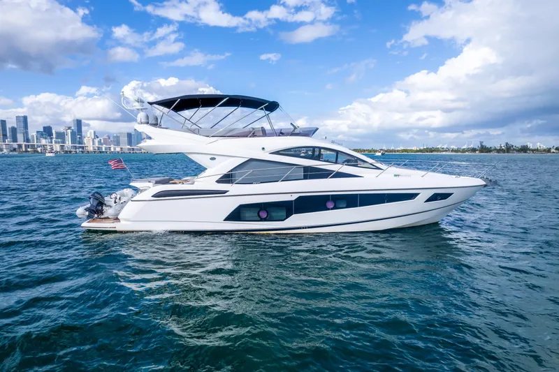 Slide: The Image of 2016 Sunseeker Manhattan 55 yacht cruising on open water under a blue sky. - 0