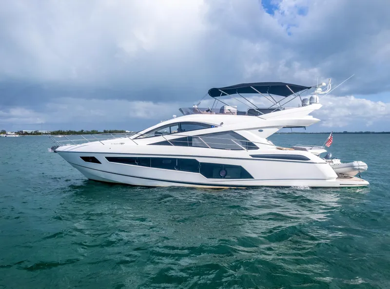 Slide: The Image of 2016 Sunseeker Manhattan 55 yacht cruising on open water under cloudy skies. - 1