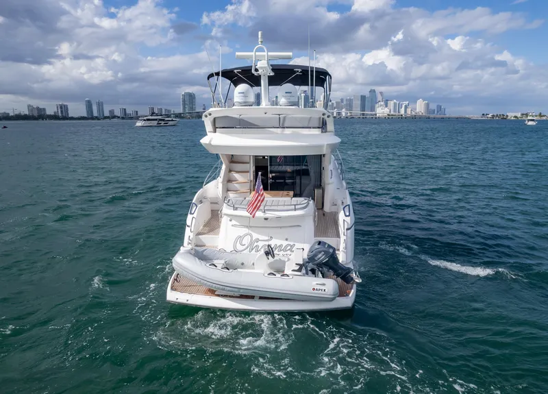 Slide: The Image of 2016 Sunseeker Manhattan 55 yacht on open water with city skyline backdrop. - 11