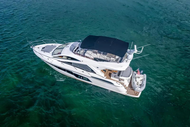 Slide: The Image of Sunseeker Manhattan 55 yacht, 2016 model, cruising on clear blue water. - 13