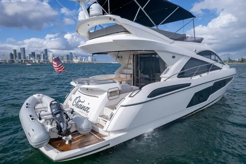 Slide: The Image of 2016 Sunseeker Manhattan 55 yacht cruising with city skyline in background. - 17