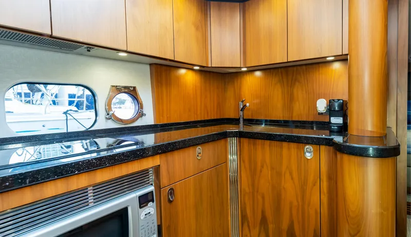 Slide: The Image of Luxurious kitchen interior of 2016 Sunseeker Manhattan 55 yacht with wood cabinetry and modern appliances. - 20