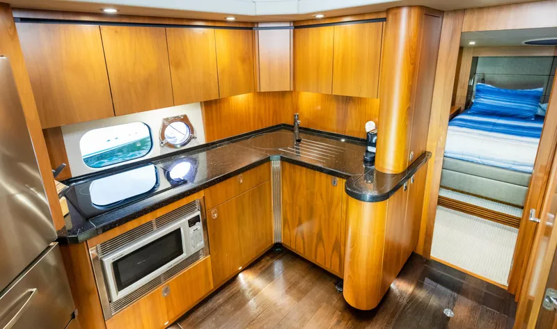 Slide: The Image of Luxurious 2016 Sunseeker Manhattan 55 yacht kitchen with wood cabinetry and modern appliances. - 21