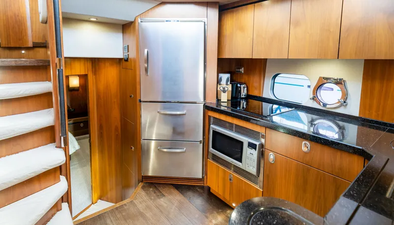Slide: The Image of Luxurious 2016 Sunseeker Manhattan 55 yacht kitchen with modern appliances and elegant wood cabinetry. - 35