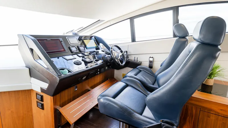 Slide: The Image of 2016 Sunseeker Manhattan 55 yacht helm with leather seats and modern navigation controls. - 44
