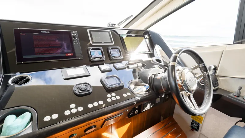Slide: The Image of Helm of 2016 Sunseeker Manhattan 55 yacht with modern navigation controls and steering wheel. - 45