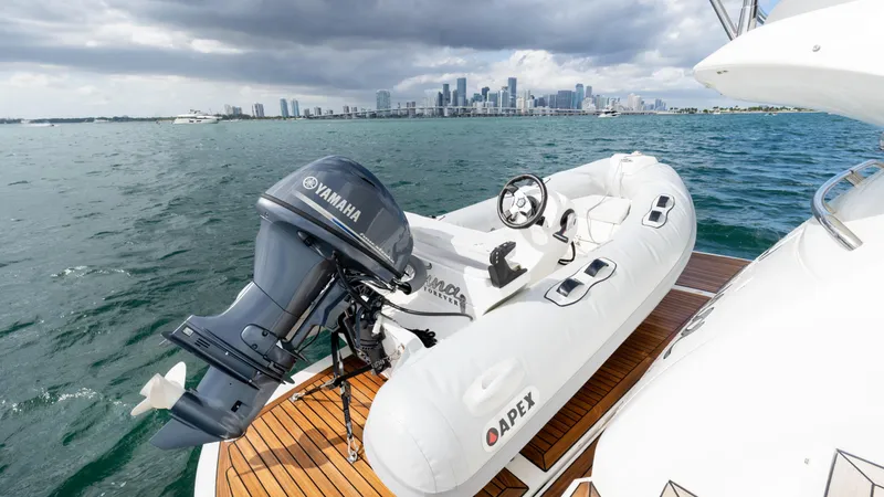Slide: The Image of White inflatable boat with Yamaha motor on Sunseeker Manhattan 55 yacht, city skyline in background. - 93