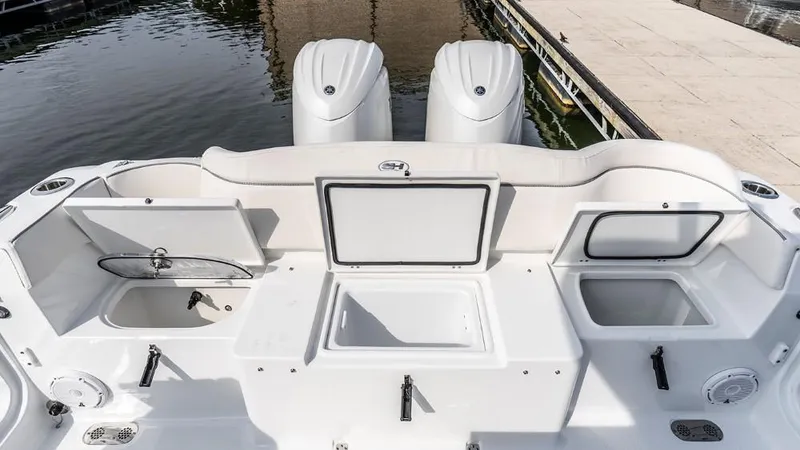 Slide: The Image of 2025 Sea Hunt Ultra 275 SE boat interior with storage compartments and twin engines. - 10