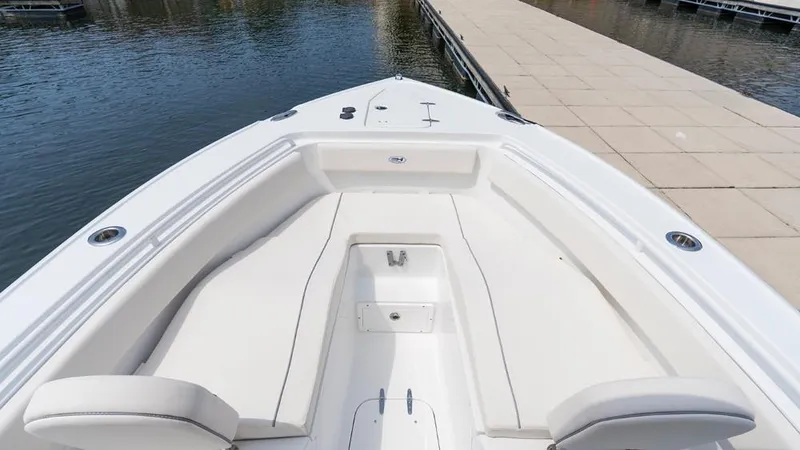 Slide: The Image of 2025 Sea Hunt Ultra 265 SE boat interior with spacious seating near dock. - 6