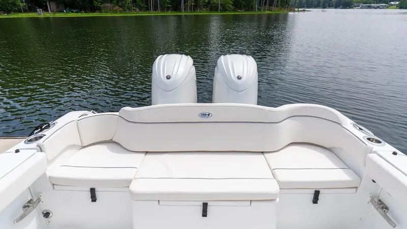 Slide: The Image of 2025 Sea Hunt Ultra 265 SE boat with dual engines on a serene lake. - 7