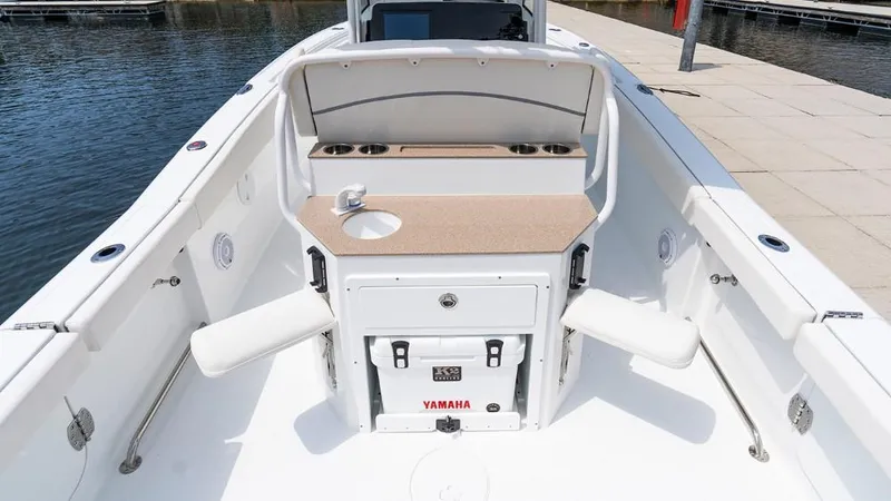 Slide: The Image of 2025 Sea Hunt Ultra 265 SE boat interior with seating and storage, docked by the water. - 9