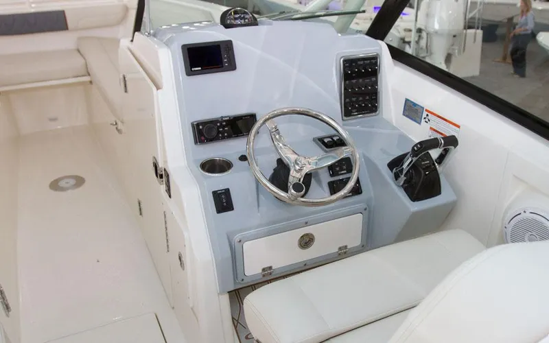 Slide: The Image of 2025 Cobia 280 DC boat cockpit with steering wheel and control panel. - 10