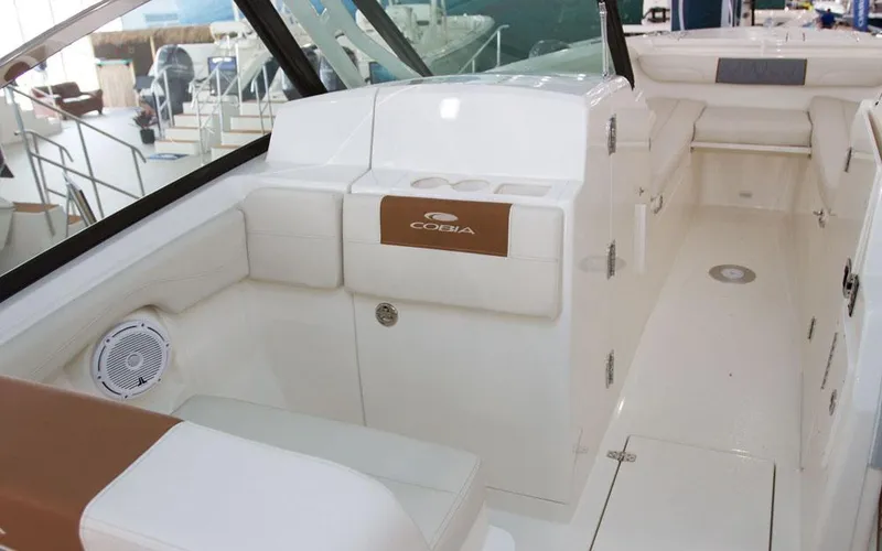 Slide: The Image of 2025 Cobia 280 DC boat interior with white seating and modern design. - 11