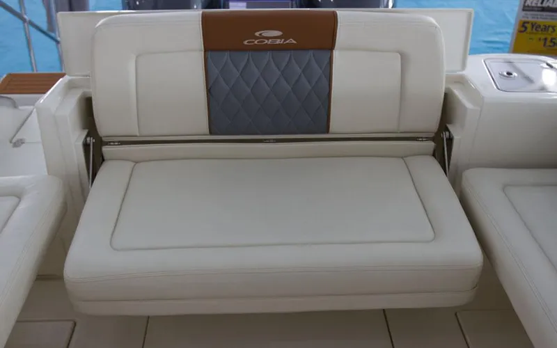 Slide: The Image of 2025 Cobia 280 DC boat seat with white and blue upholstery, showcasing luxury design. - 19