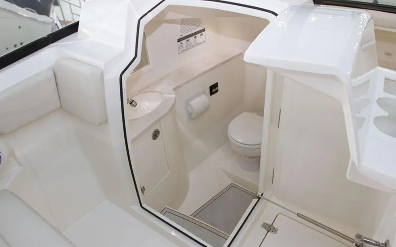 Slide: The Image of 2025 Cobia 280 DC boat interior with compact bathroom and sink. - 20