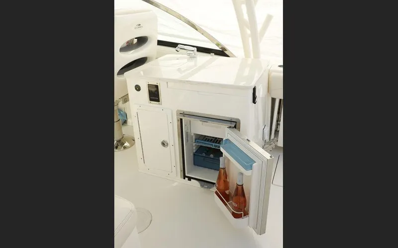 Slide: The Image of 2025 Cobia 280 DC boat interior with open mini fridge and beverages. - 22