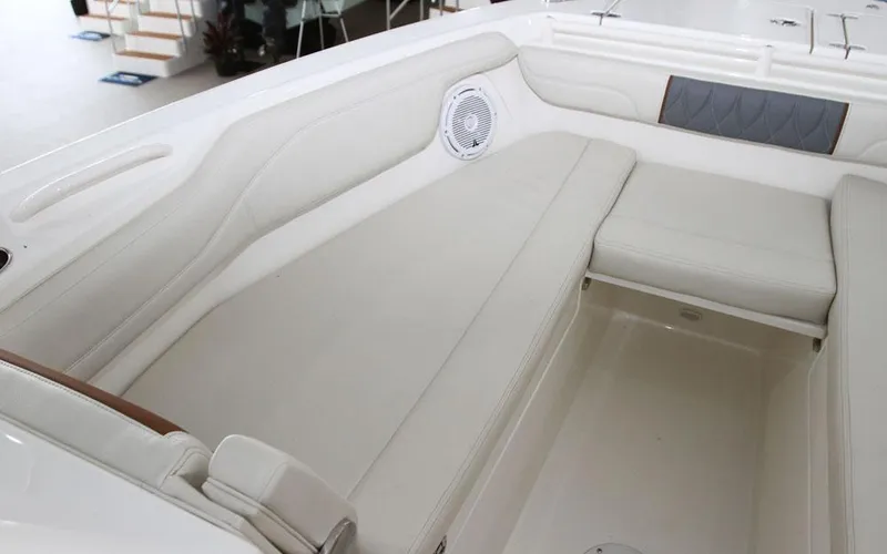 Slide: The Image of 2025 Cobia 280 DC boat interior with white cushioned seating and speaker. - 7