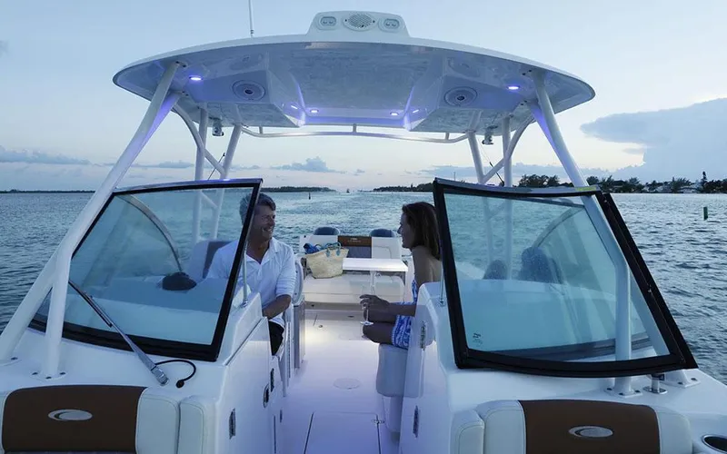 Slide: The Image of 2025 Cobia 280 DC boat cruising at sunset with passengers enjoying the view. - 8