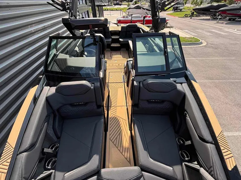 Slide: The Image of 2025 MasterCraft XSTAR23 boat interior with sleek black seating and modern design. - 12