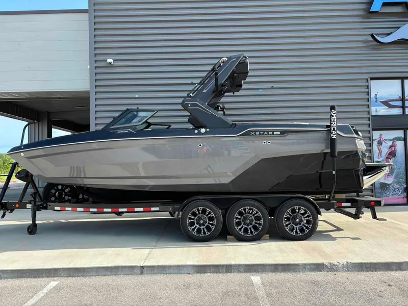 Slide: The Image of 2025 MasterCraft XSTAR23 boat on trailer, sleek design, parked outside a building. - 5
