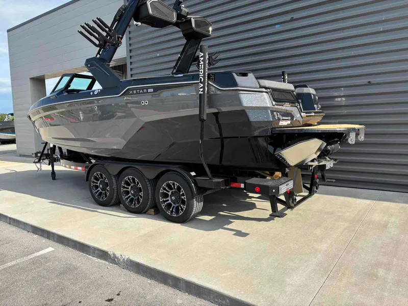 Slide: The Image of 2025 MasterCraft XSTAR23 boat on a trailer, parked outdoors. - 6