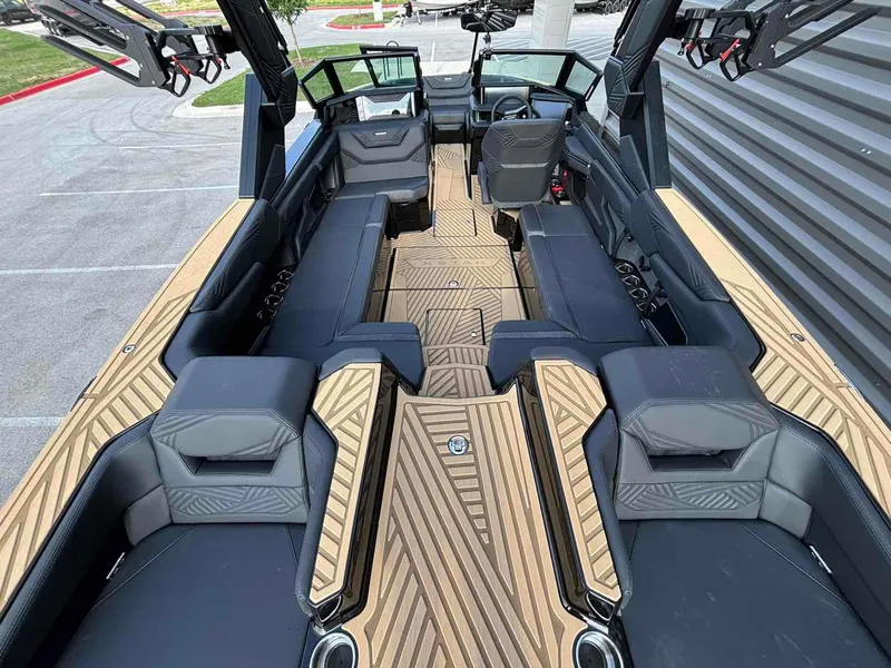 Slide: The Image of 2025 MasterCraft XSTAR23 boat interior with sleek black seating and stylish wood-patterned flooring. - 7