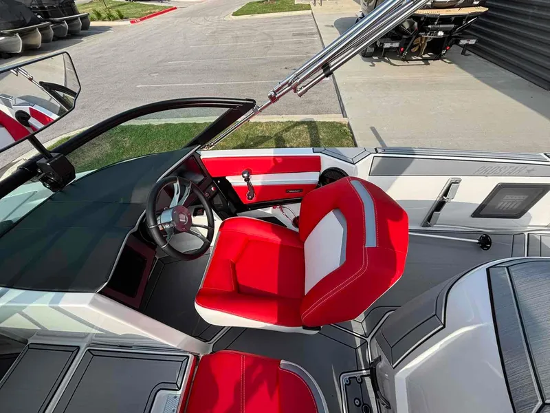 Slide: The Image of 2025 MasterCraft ProStar boat interior with red and white seating, modern dashboard, and steering wheel. - 6