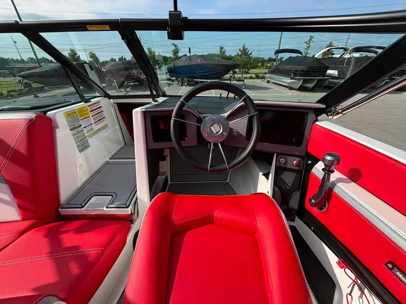 Slide: The Image of 2025 MasterCraft ProStar boat interior with red seating and modern steering wheel. - 7