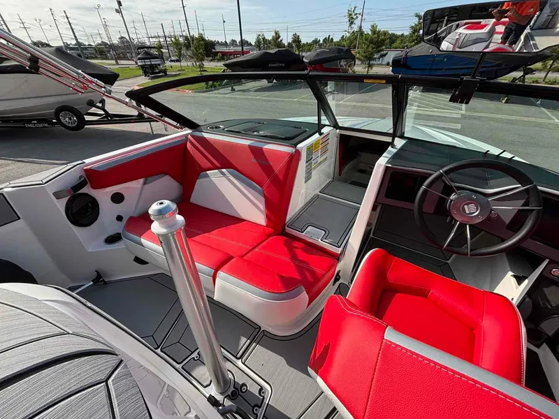 Slide: The Image of 2025 MasterCraft ProStar boat interior with red and white seating, modern dashboard, and steering wheel. - 8