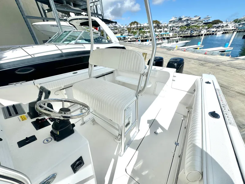 Slide: The Image of 2005 Sea Fox 287 Center Console boat interior at marina, featuring helm and seating. - 13