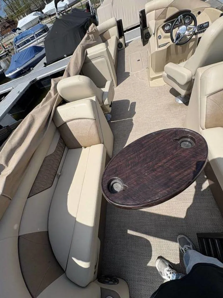 Slide: The Image of 2020 Crest Classic DLX 240 SLC boat interior with beige seating and oval table. - 10