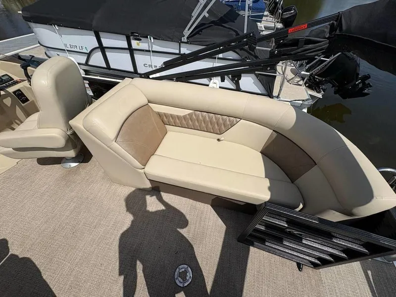 Slide: The Image of 2020 Crest Classic DLX 240 SLC boat interior with beige seating and carpet flooring. - 11