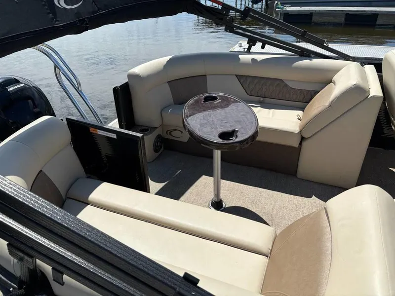 Slide: The Image of 2020 Crest Classic DLX 240 SLC pontoon boat interior with beige seating and table. - 13