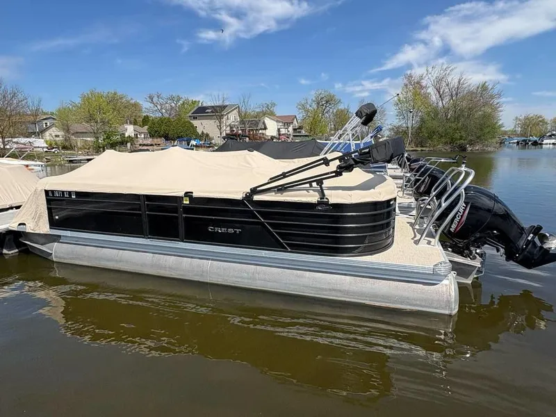 Slide: The Image of 2020 Crest Classic DLX 240 SLC pontoon boat docked on a calm lake. - 15
