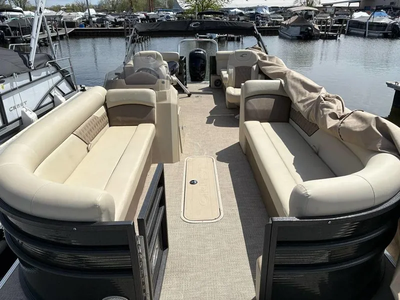 Slide: The Image of 2020 Crest Classic DLX 240 SLC pontoon boat with beige seating, docked at marina. - 3