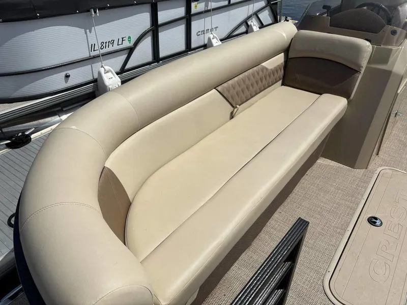 Slide: The Image of 2020 Crest Classic DLX 240 SLC boat with beige seating and carpeted deck. - 4