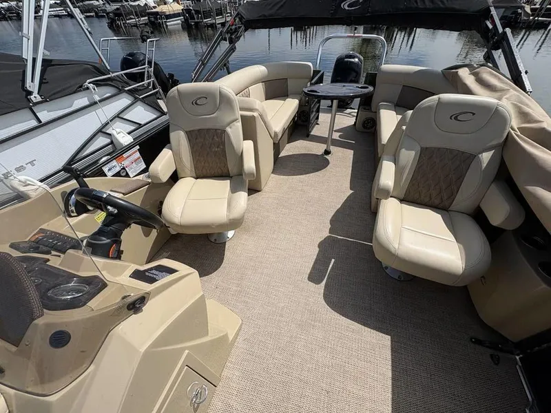 Slide: The Image of 2020 Crest Classic DLX 240 SLC pontoon boat interior with beige seating and helm. - 6