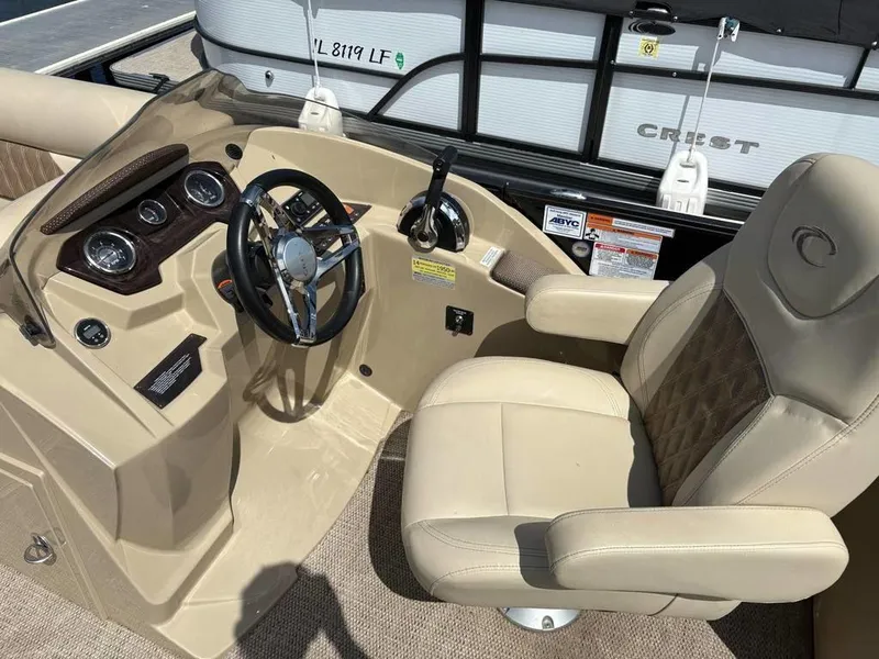 Slide: The Image of 2020 Crest Classic DLX 240 SLC boat interior with steering wheel and captain's chair. - 7