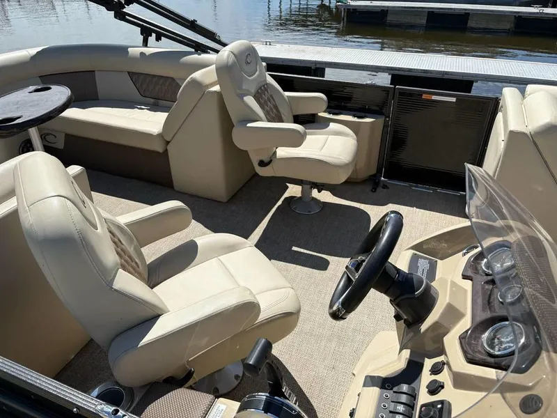 Slide: The Image of 2020 Crest Classic DLX 240 SLC boat interior with beige seating and steering console. - 8